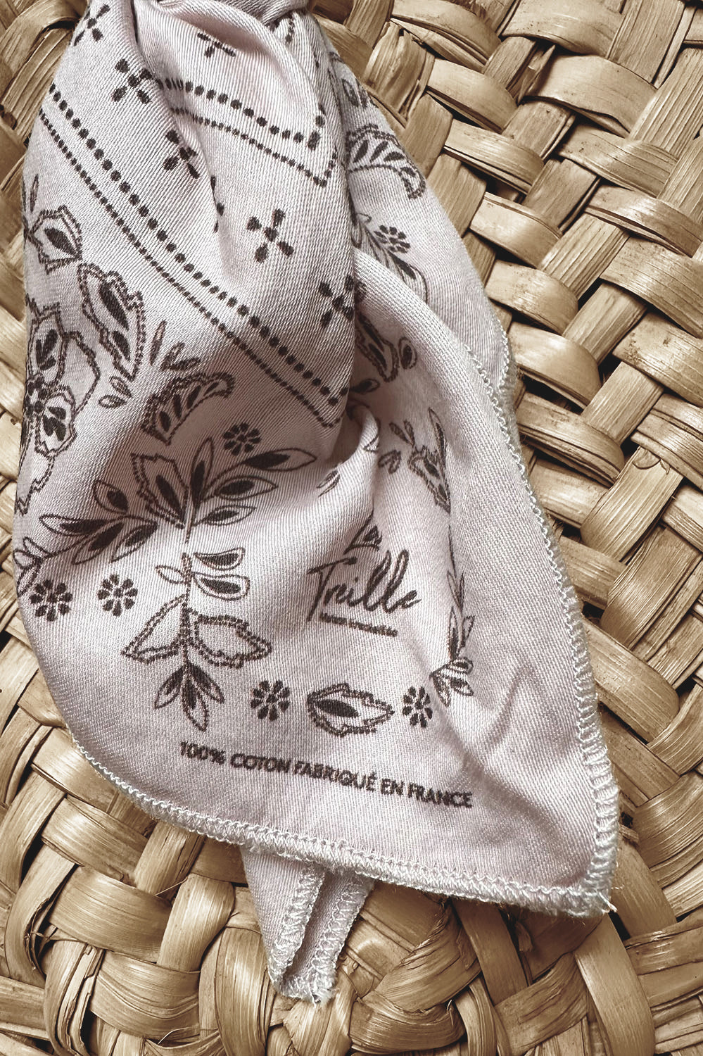 Écharpe légère en coton pétale avec motif floral délicat imprimé, soulignant un savoir-faire français et un style bohème élégant posé sur un tissage naturel.