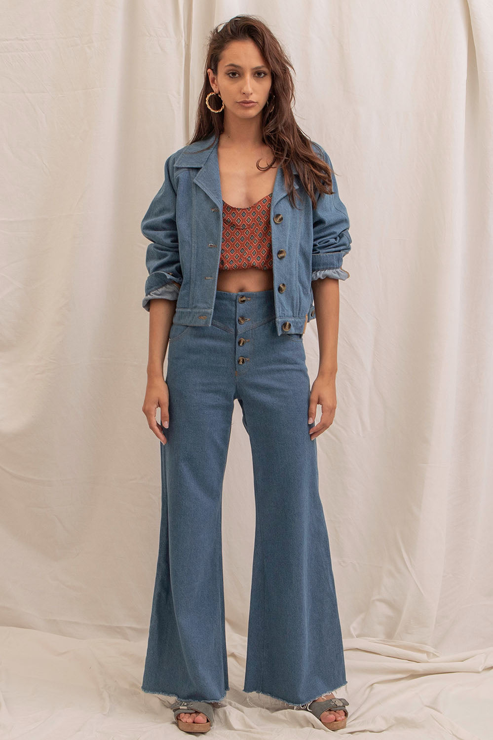 Ensemble blouson Jane et pantalon taille haute en denim, porté avec un top imprimé.
