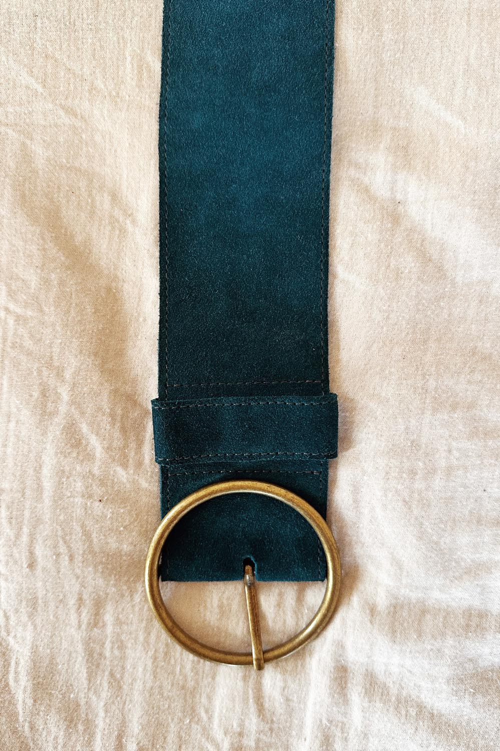 Vue de face de la ceinture Dolly bleu gitane avec boucle ronde en laiton – La Treille maison ensoleillée