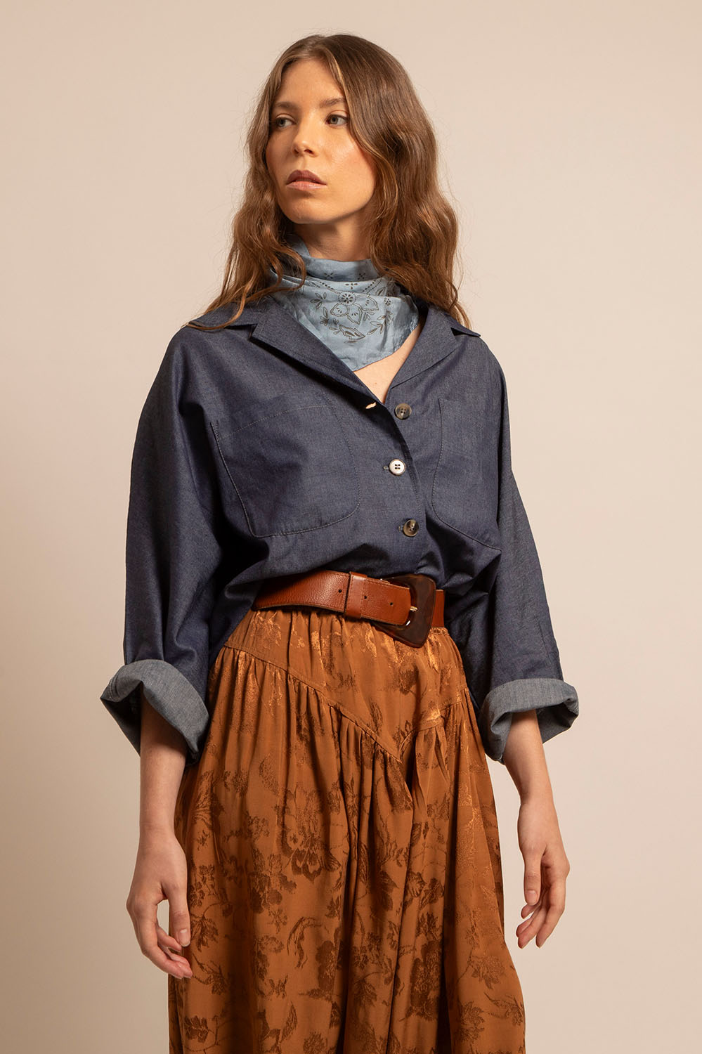 Zoom sur le col pelle à tarte et les poches de la chemise Romy, avec foulard bleu clair noué au cou.