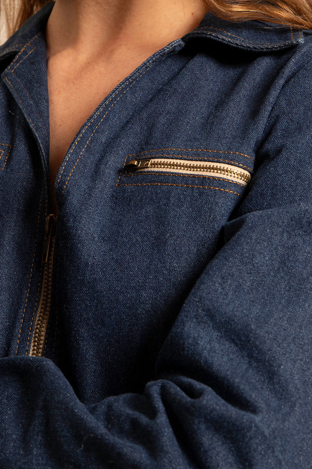 Zoom sur le zip doré et les surpiqûres contrastées de la combinaison Mila