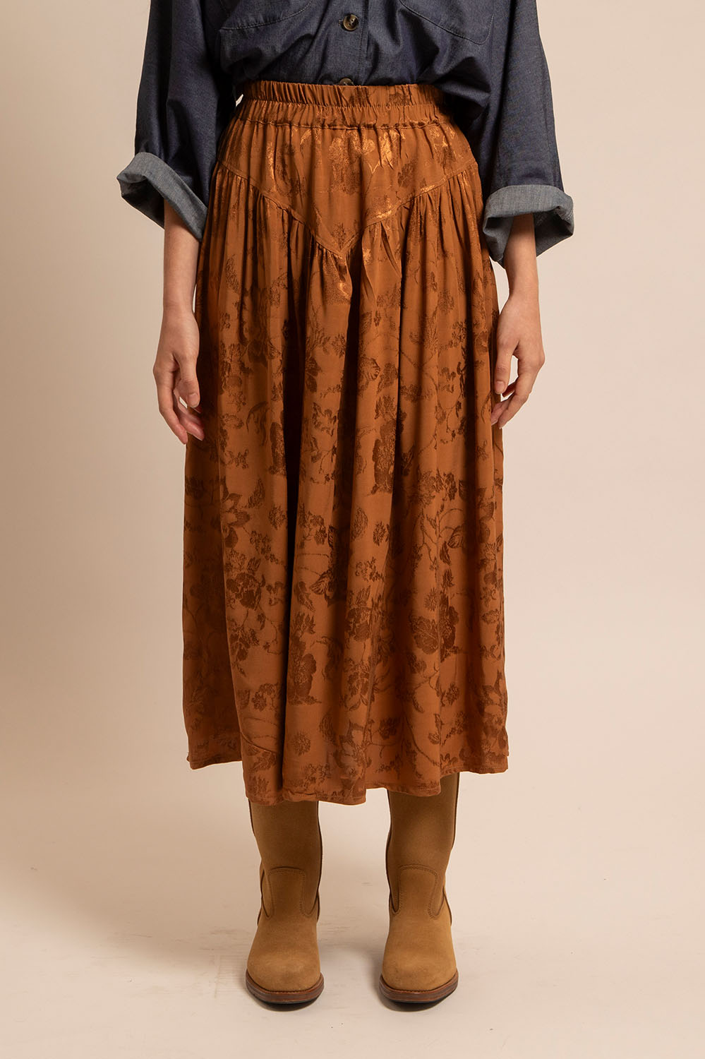 Zoom sur le détail de la taille en V et le motif jacquard de la jupe Léna cognac.