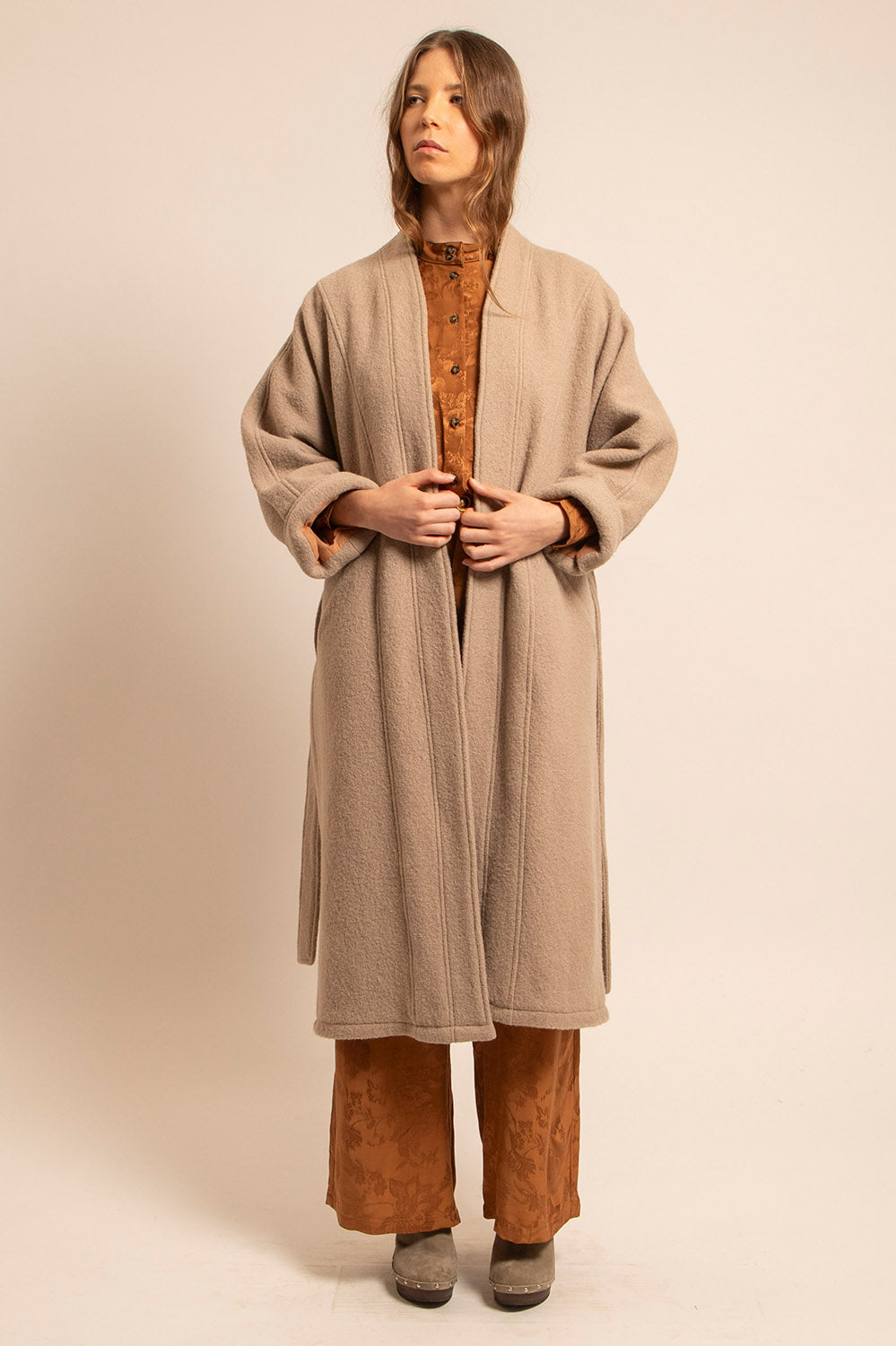 Manteau Claudia beige porté main sur la taille, matière laine épaisse