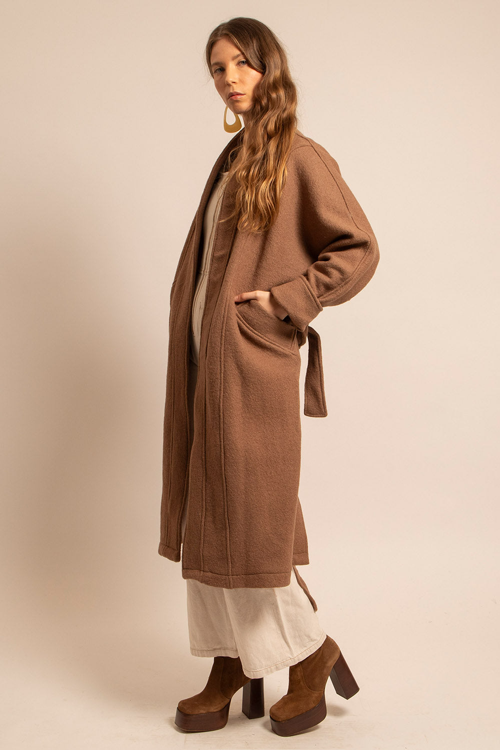 Vue de profil du manteau Claudia en laine camel ceinturé à la taille