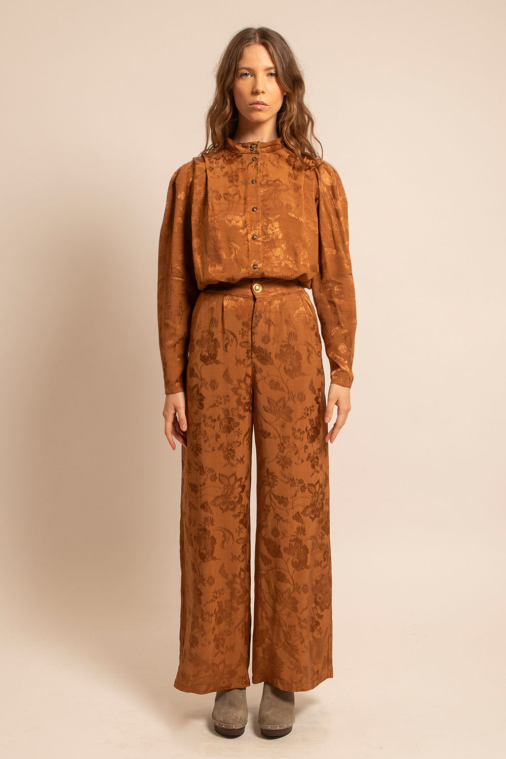 Femme portant le pantalon Alba en jacquard cognac, vue de face avec chemise assortie.