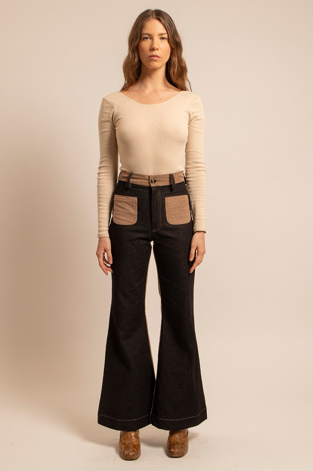 Vue de face du pantalon Farrah porté, coupe patte d’eph et poches contrastées.