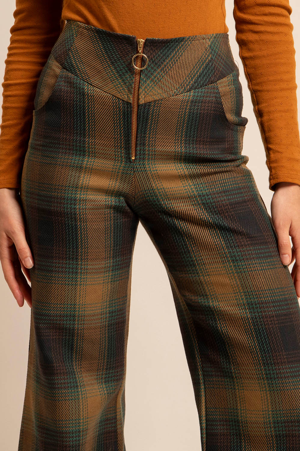 Gros plan sur la ceinture structurée et le zip doré du pantalon Luigi.