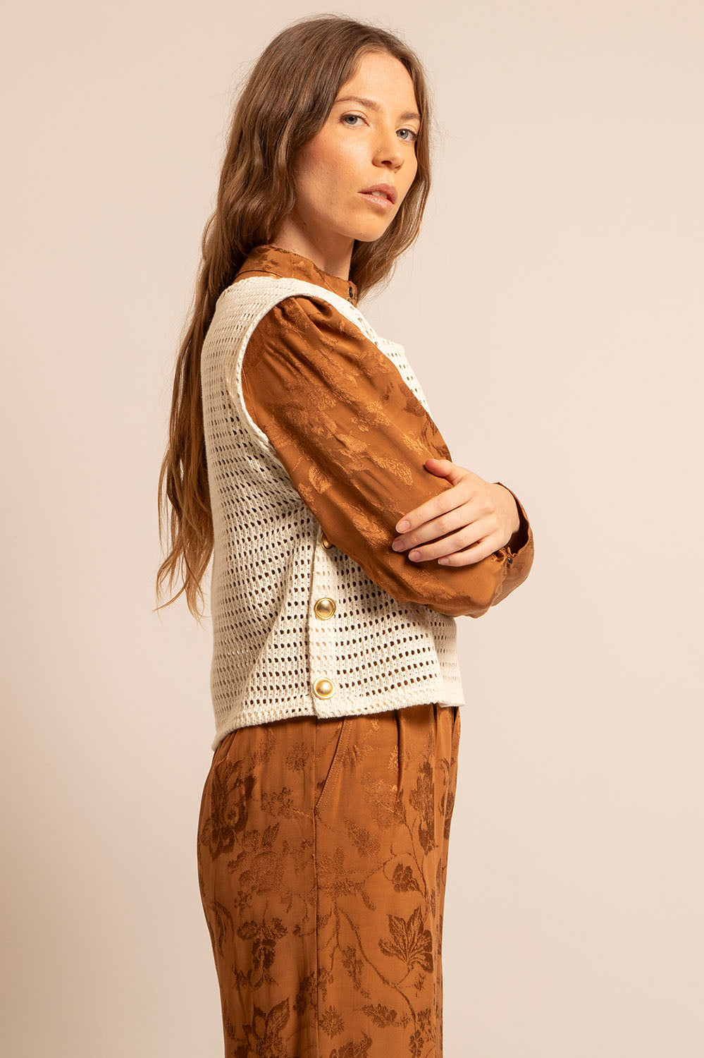 Vue de profil du Top Betty avec détails des boutons dorés latéraux sur fond caramel.