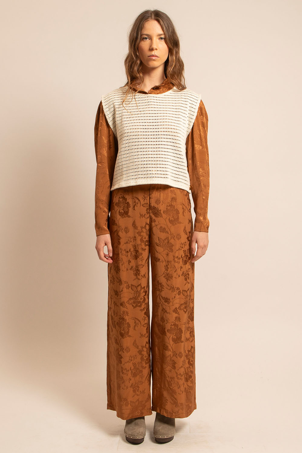 Top Betty en crochet naturel porté de face, superposé sur une chemise caramel, boutons dorés visibles sur le côté.