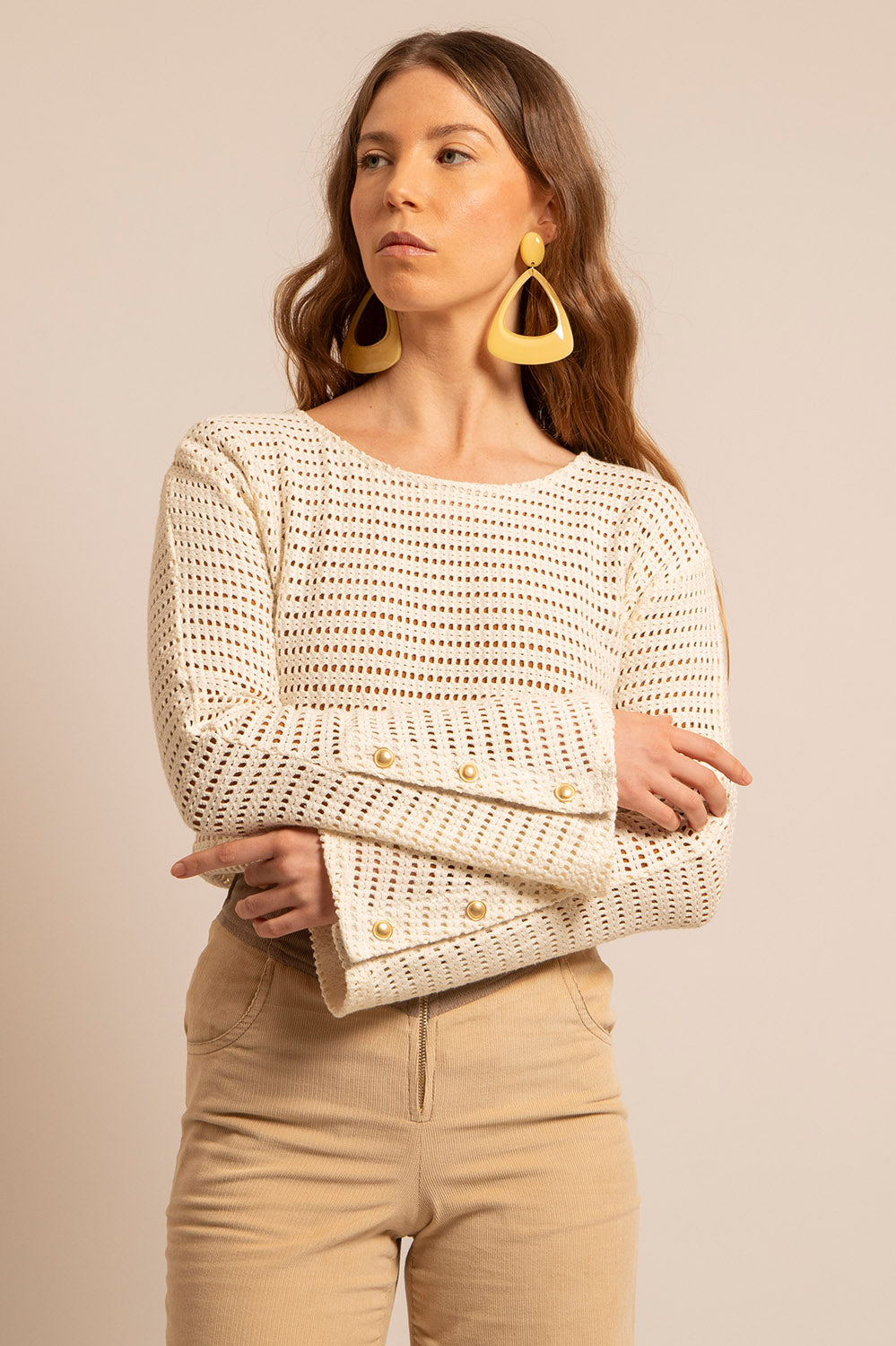 manches.jpg Zoom sur les manches du Top Holly : détails des boutons dorés et maille ajourée naturelle.