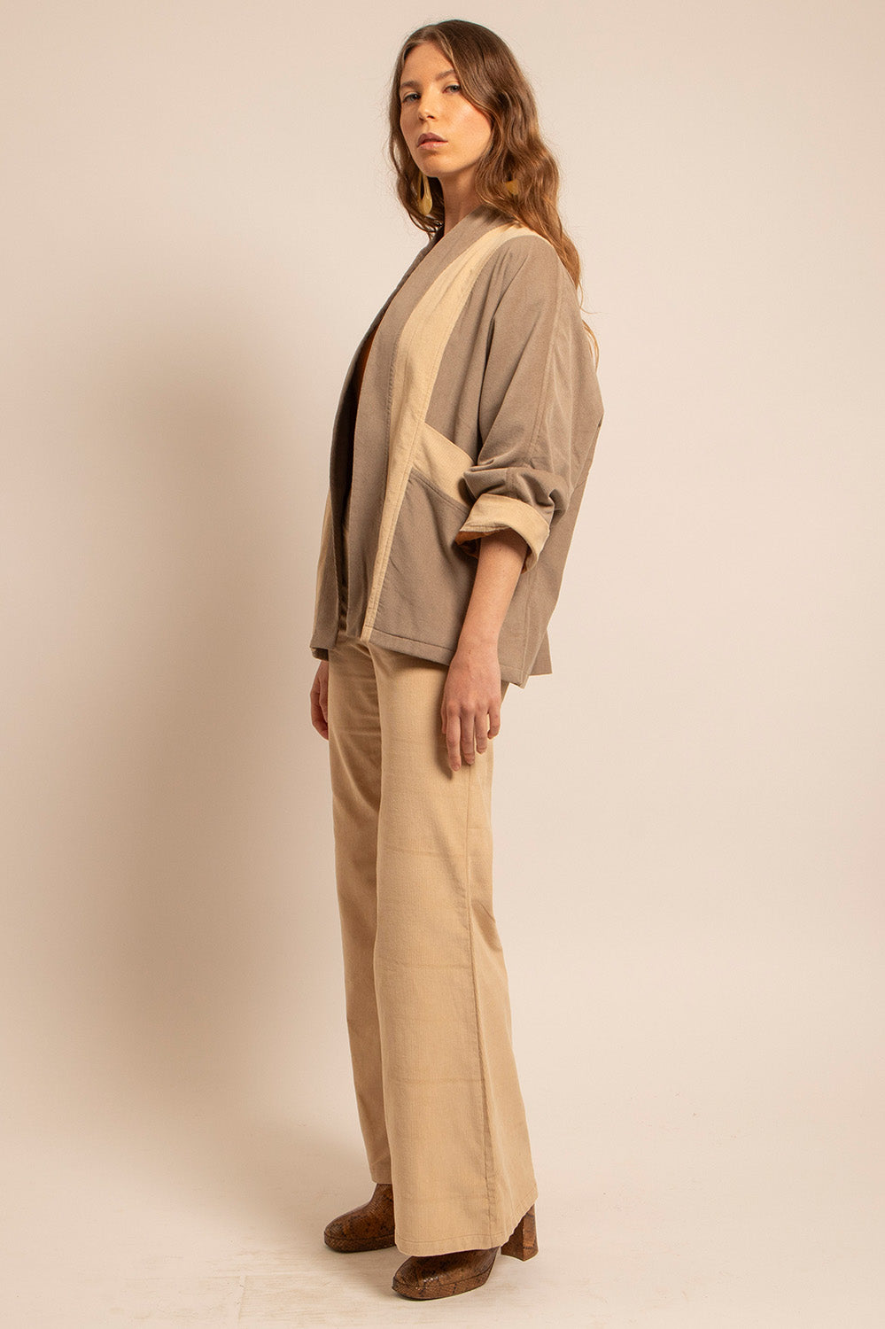 Vue profil de la veste Gina avec ses empiècements contrastés et manches retroussées.