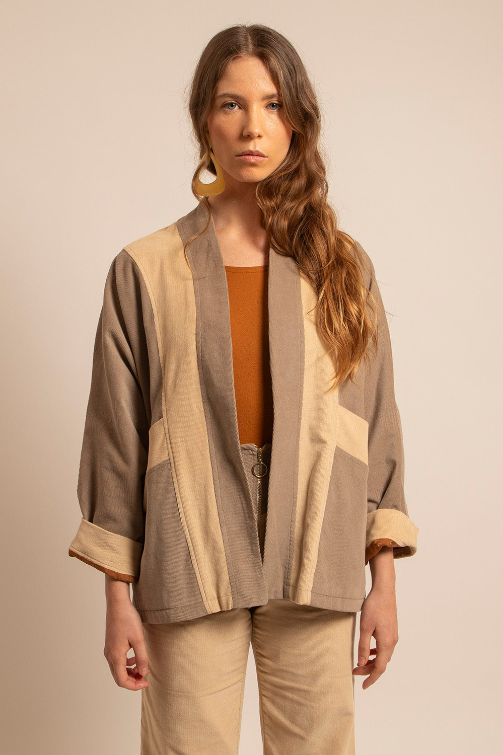 Vue profil de la veste Gina avec ses empiècements contrastés et manches retroussées.