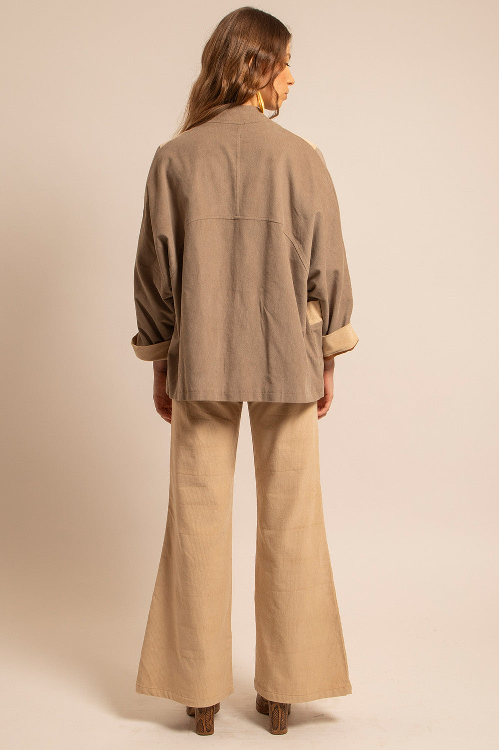 Vue profil de la veste Gina avec ses empiècements contrastés et manches retroussées.