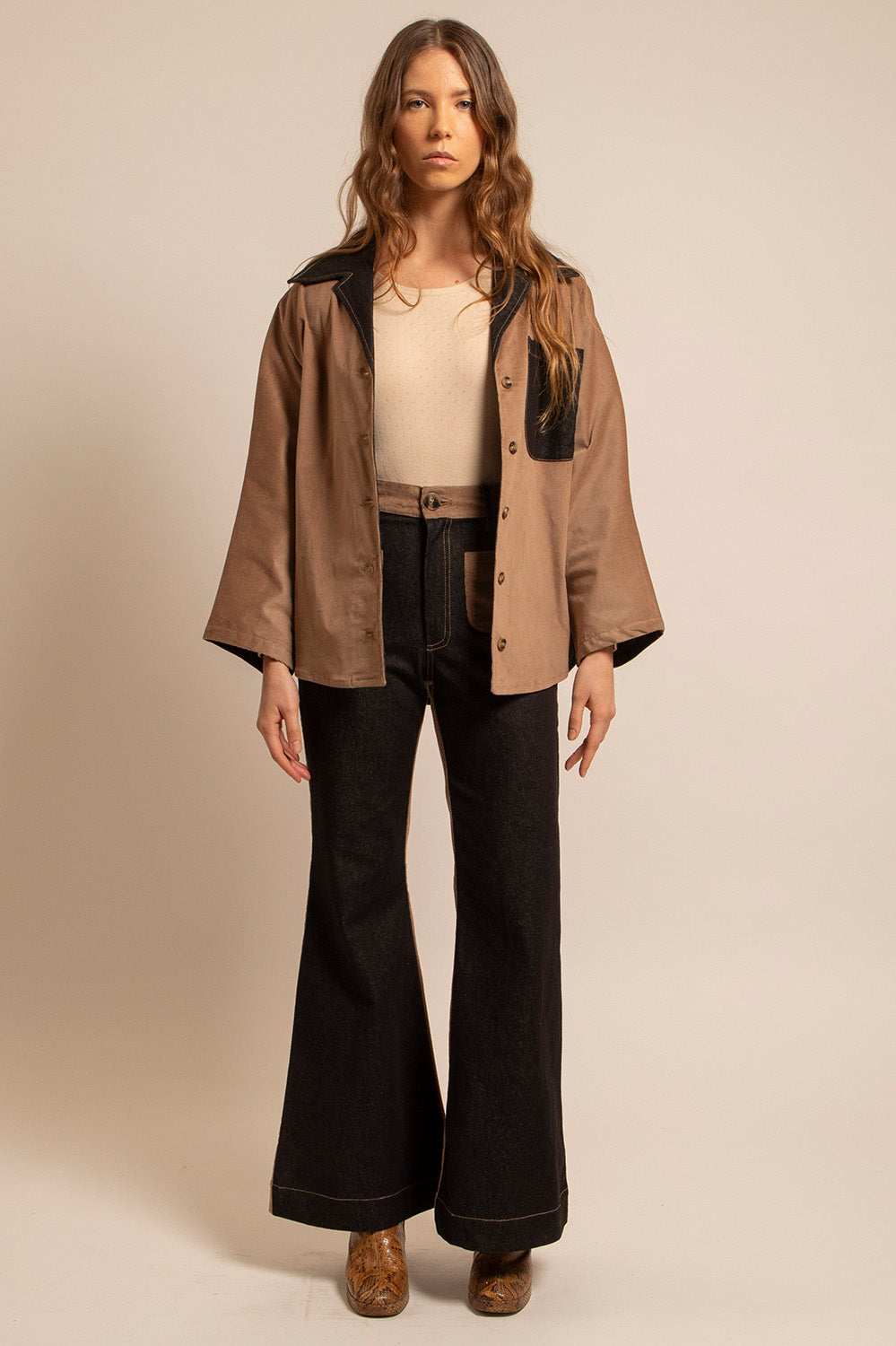 Vue en pied de la surchemise Jimmy portée ouverte sur un top écru, avec un pantalon flare.