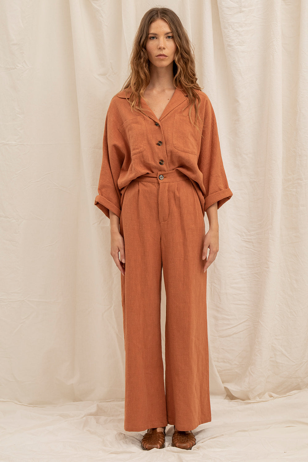 Pantalon Alba coloris argile – coupe ample, taille haute et plis élégants devant.