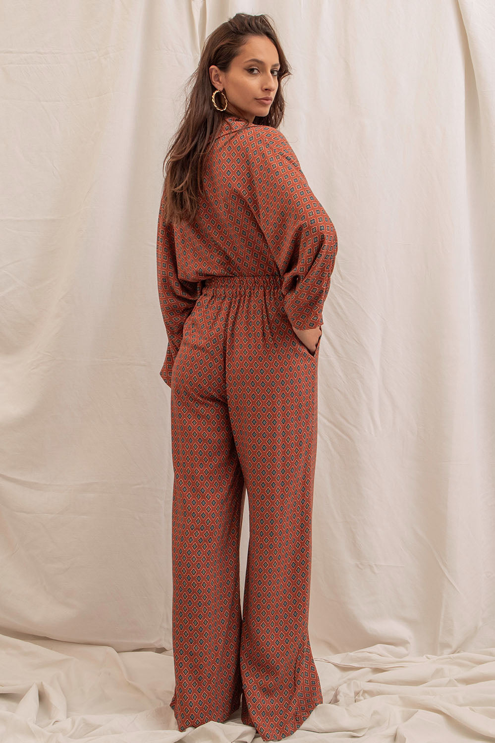 Pantalon Alba vu de dos, taille haute élastiquée, coupe ample et poches pratiques, imprimé rouge Terre du Sud.