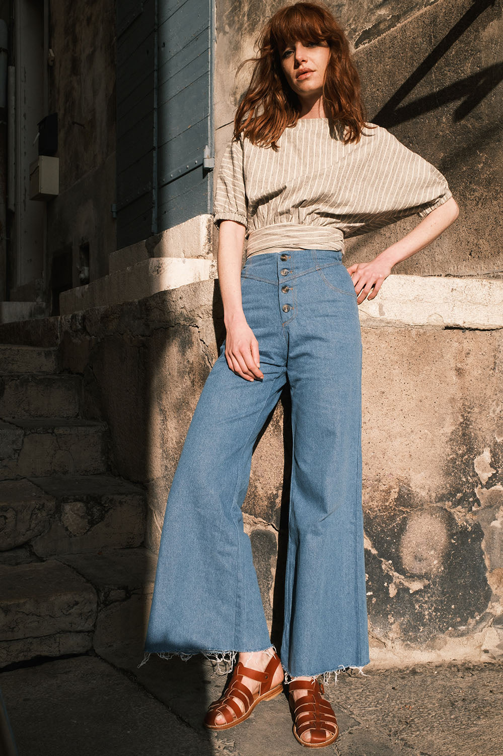 Pantalon Maria en denim bleu jeans, coupe flare taille haute, vu de face – La Treille maison ensoleillée.
