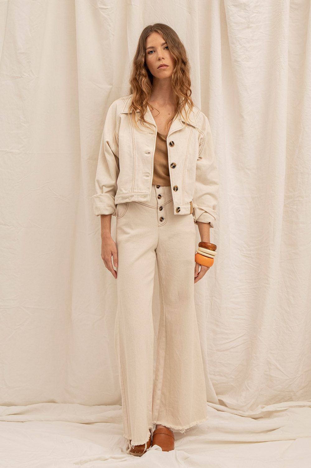 Total look avec le pantalon flare Maria écru et le blouson Jane assorti, ambiance naturelle et silhouette 70s.