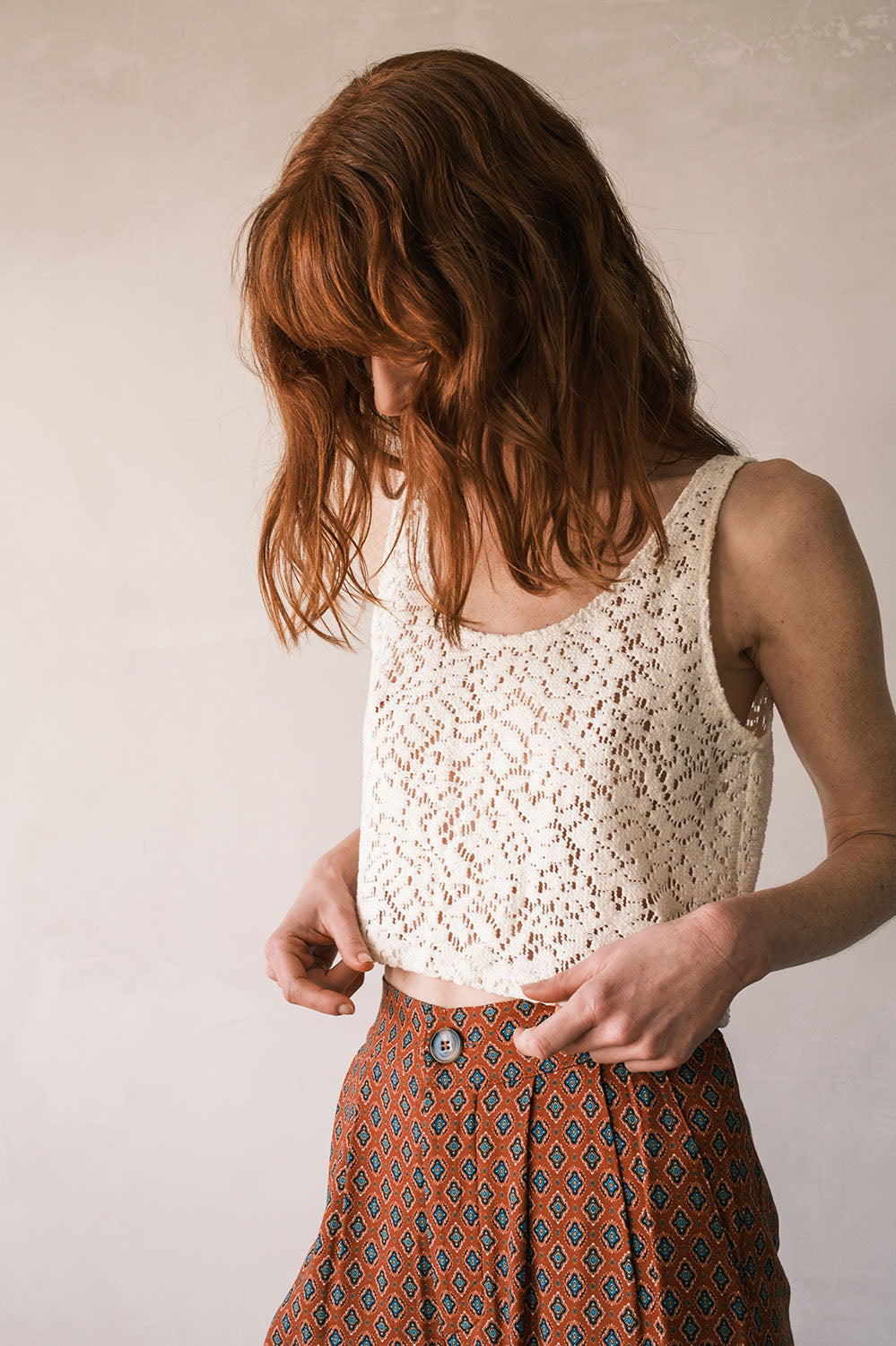 Zoom sur le top Lina en dentelle épaisse motif fleuri, coupe courte et décolleté arrondi.