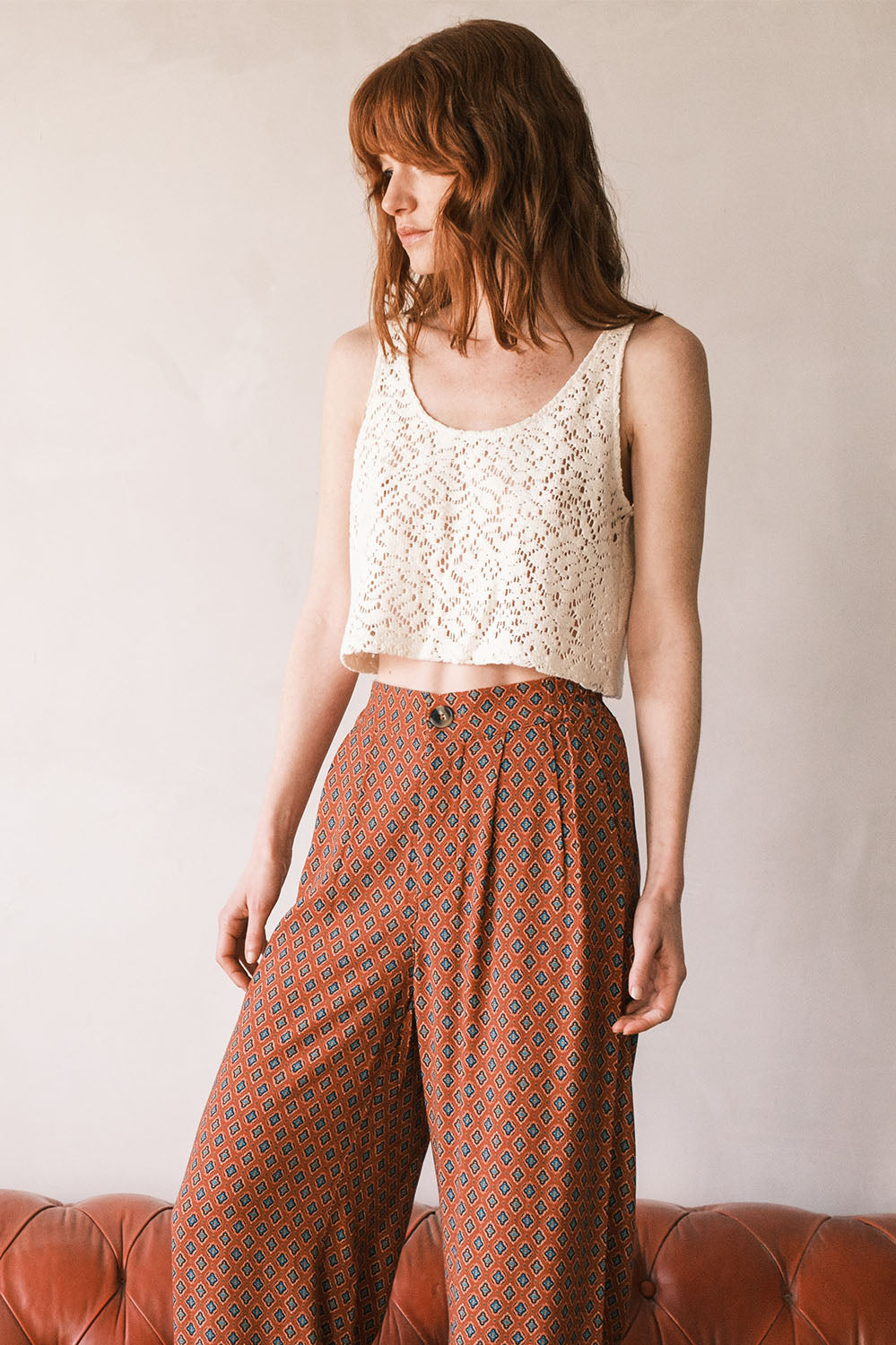 Top court en dentelle façon crochet porté avec un pantalon taille haute, vue de face.