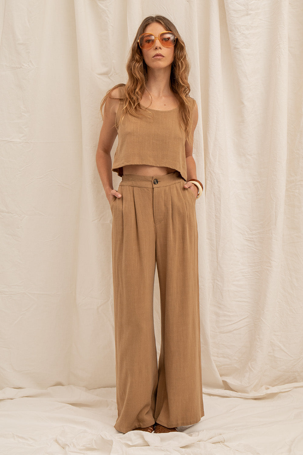 Top court Lina en coloris latte, à la coupe fluide et au tombé léger, porté avec un pantalon assorti.