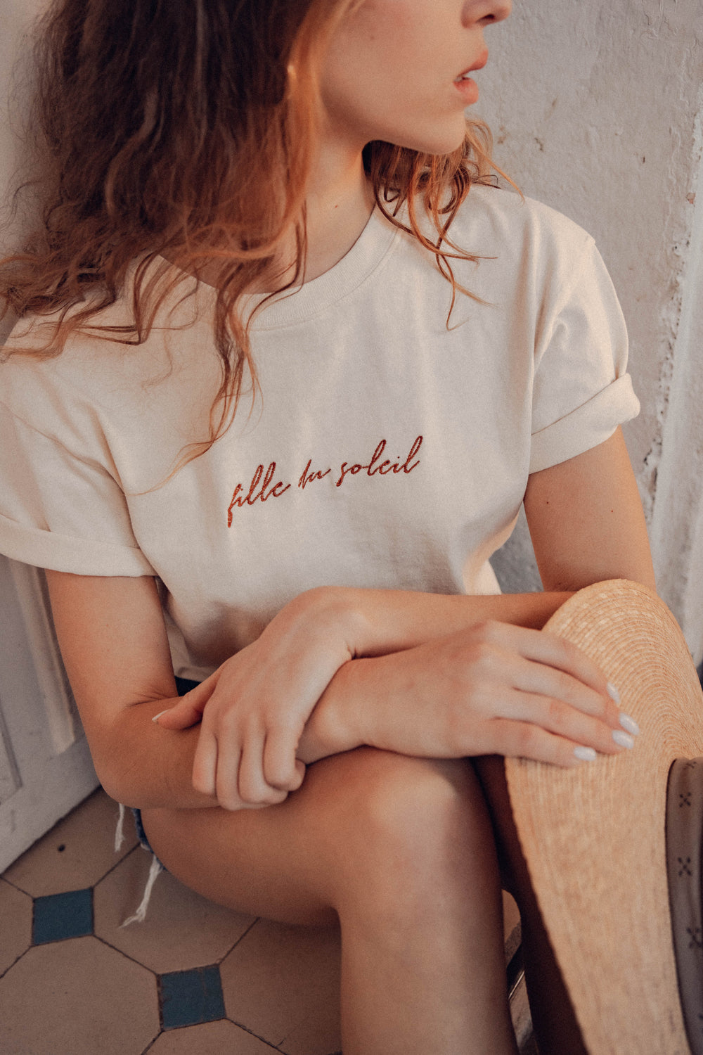 Profil féminin avec le tee-shirt brodé "Fille du Soleil", ambiance douce et solaire.